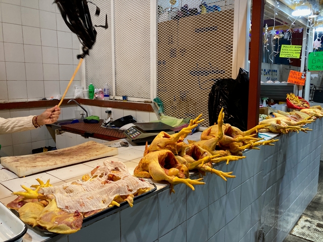       Market stall with whole chickens on display.
  