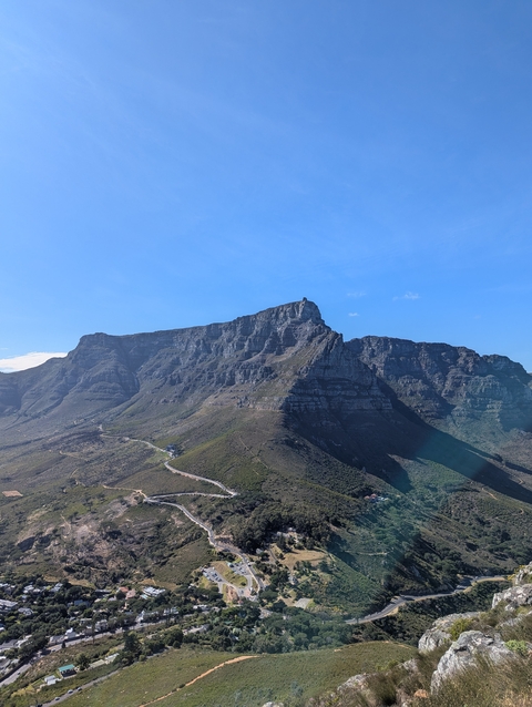 View of a large, rugged mountain range under a clear blue sky.