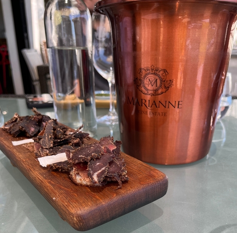 A close-up of a tray with food in front of a wine estate ice bucket.