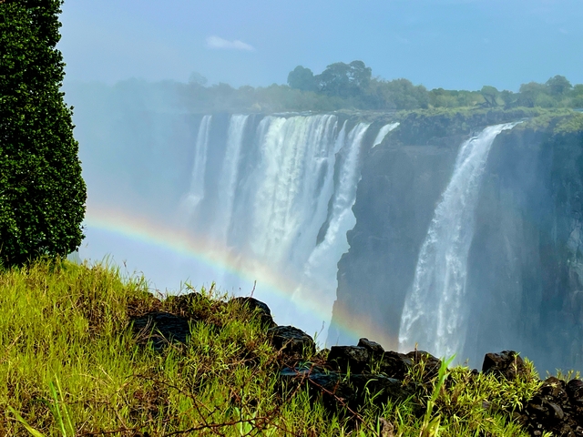 A spectacular view of a waterfall with a rainbow in front.