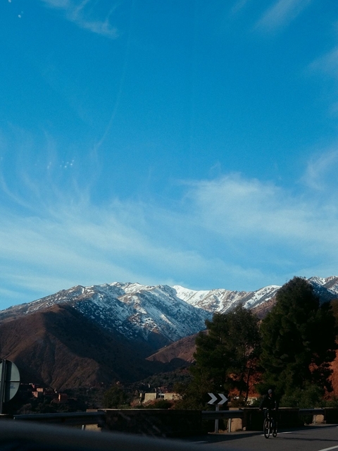       A distant view of snow-capped mountains under a clear sky.
  