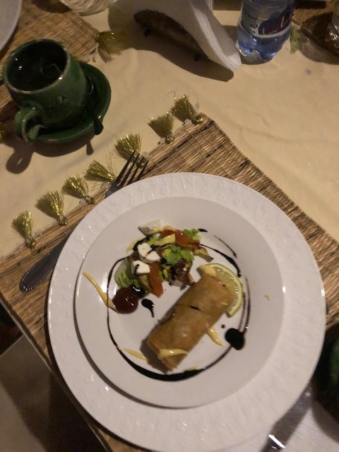       A plate with assorted food on a woven placemat.
  