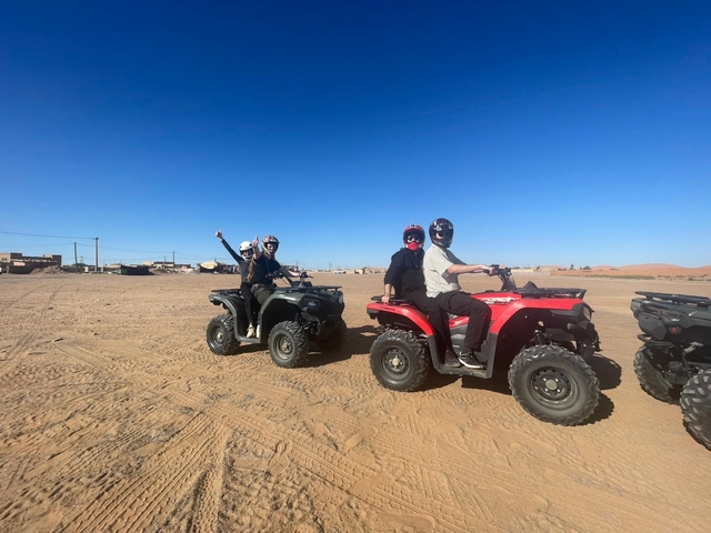       People riding ATVs in a desert landscape.
  