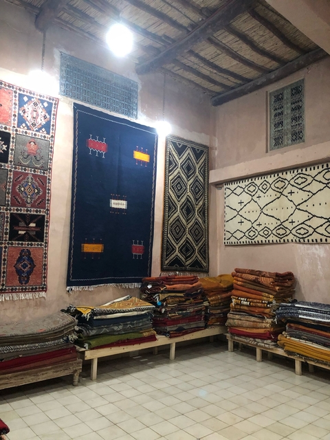       Shop interior showcasing brightly colored and patterned rugs.
  