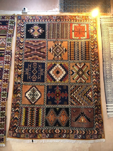       A collection of intricately designed rugs hanging on walls.
  