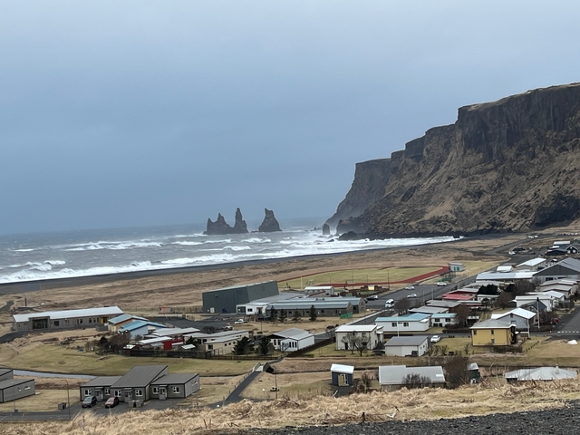       Coastal village with dramatic cliffs and crashing waves.
  