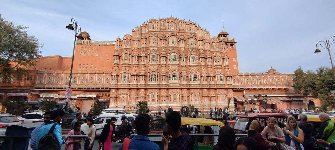 Hawa Mahal facade with people and vehicles.
