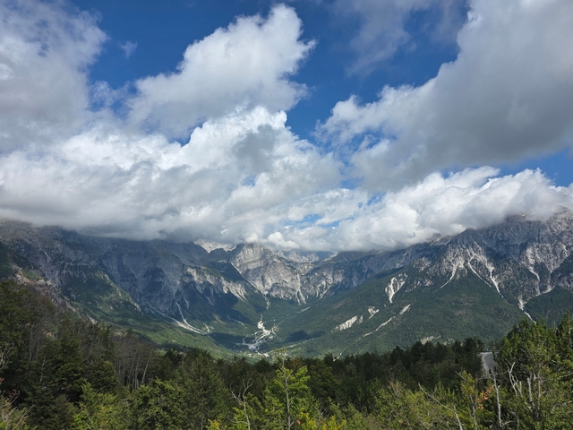 Cloud-covered mountains in a lush green landscape.