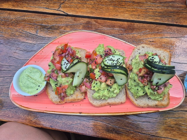       Plate of food featuring avocado toast and cucumber slices.
  