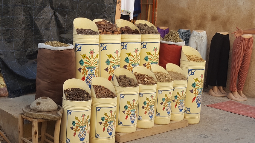 Spices and herbal products displayed in elaborately decorated containers.