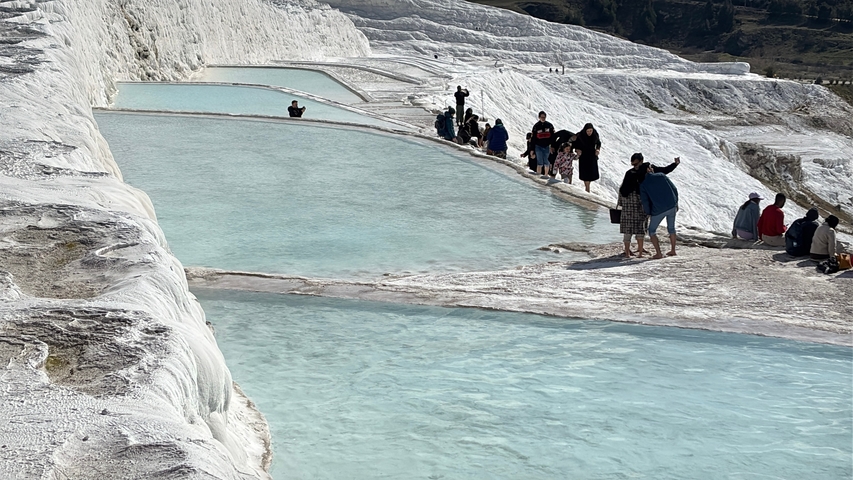       Tourists exploring the travertine terraces of Pamukkale.
  