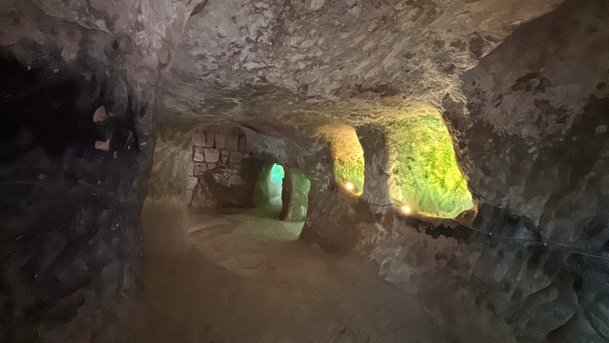       Illuminated interior of an ancient underground cave.
  