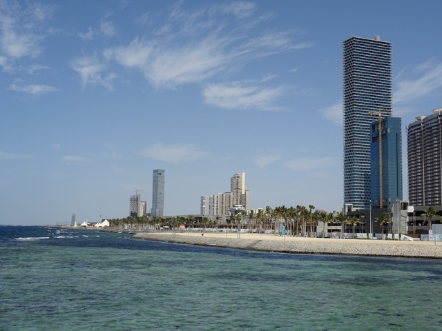 Coastal cityscape with tall modern buildings along the shoreline.