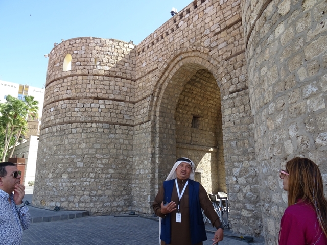 Guided tour in front of an ancient stone gate.