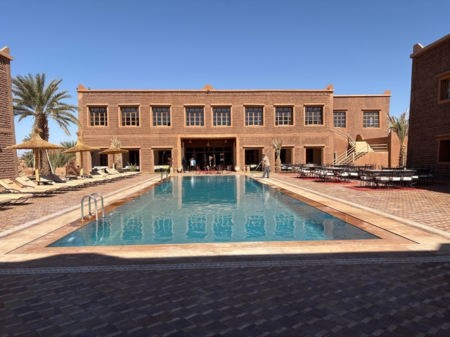       Luxurious hotel with a large pool and palm trees.
  