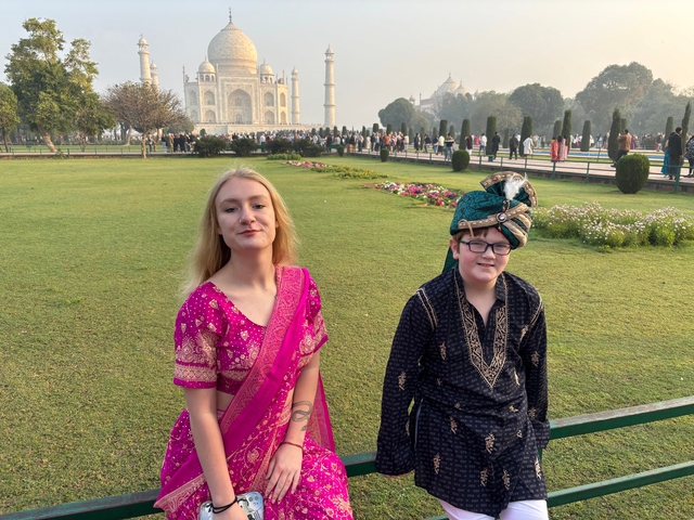 Two people dressed in traditional attire at the Taj Mahal.