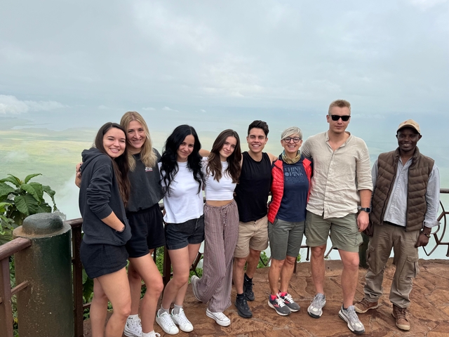 Group of people posing for a photo with a scenic landscape background.