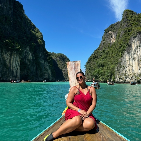 Person on a boat surrounded by stunning limestone cliffs and blue waters.
