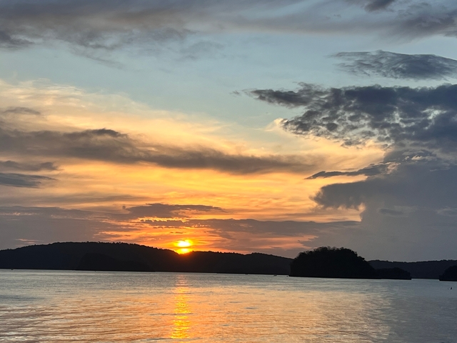 Beautiful sunset with the sun setting over the horizon and dramatic clouds.