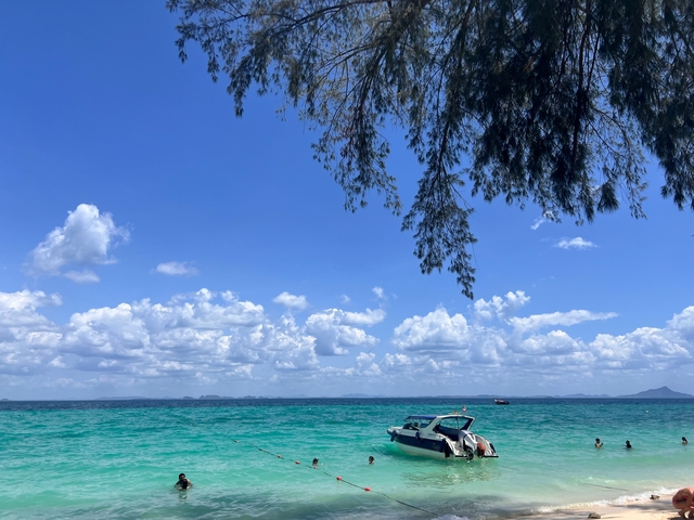 Ocean view from a beach with clear blue skies and distant islands.