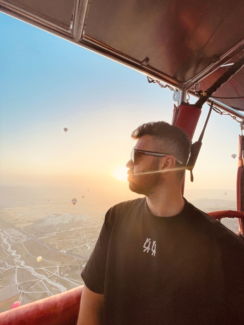       Person enjoying a hot air balloon ride at sunrise.
  