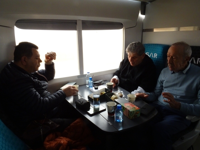       Group of people dining in a train compartment
  