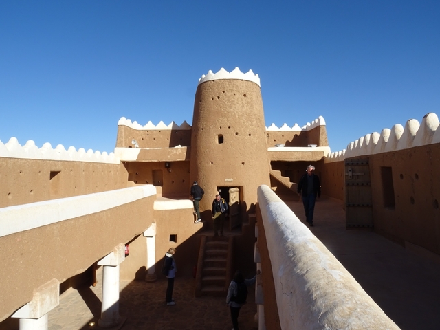       Interior of a traditional fortress with visitors
  