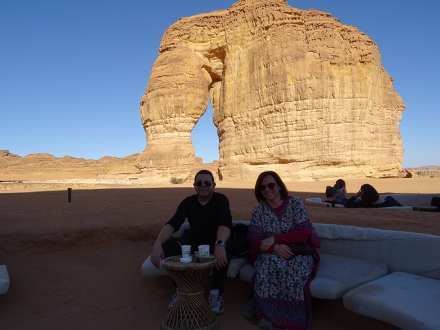       Couple sitting in front of rock formation
  