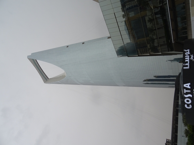       Modern skyscraper with curved architecture and Costa sign
  