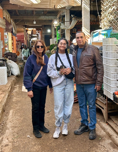       Three people in a market setting.
  