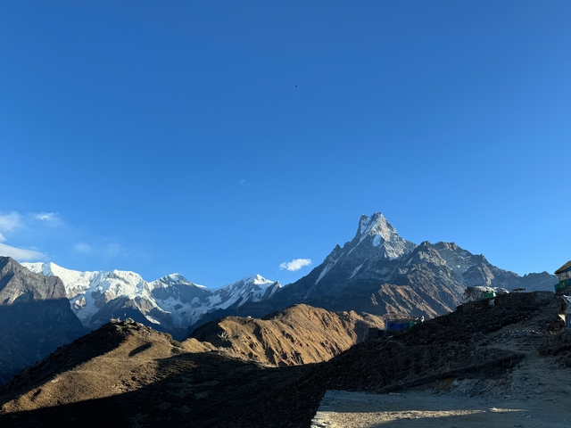 Mountain range with clear sky and sunlight illuminating peaks.