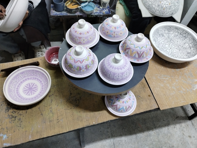       Decorated ceramic tajine pots on display.
  