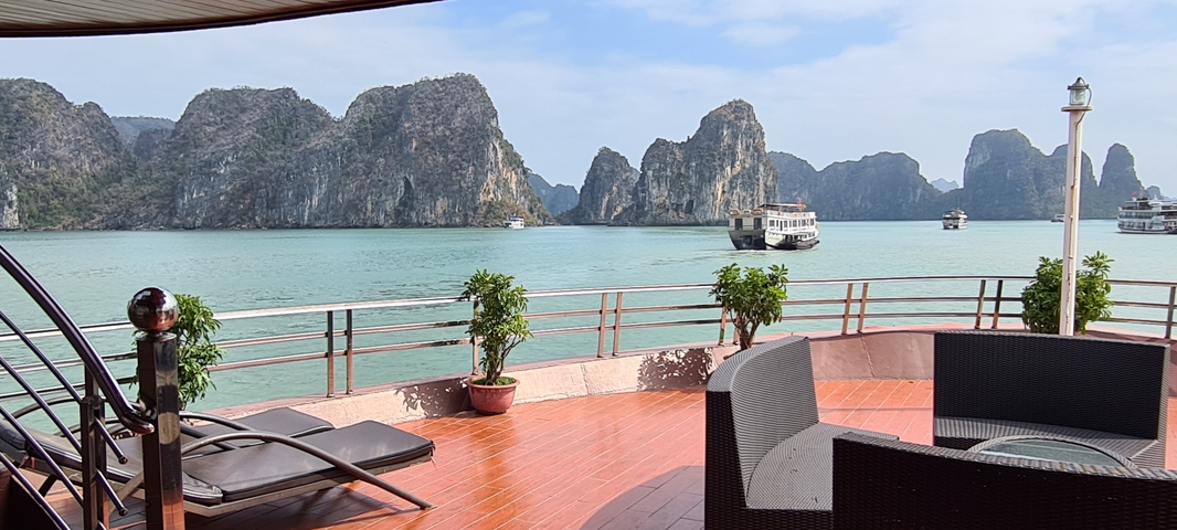       View from boat deck of towering limestone islands.
  