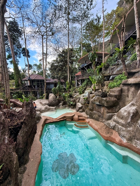       Natural rock formations with small pools and rustic buildings.
  