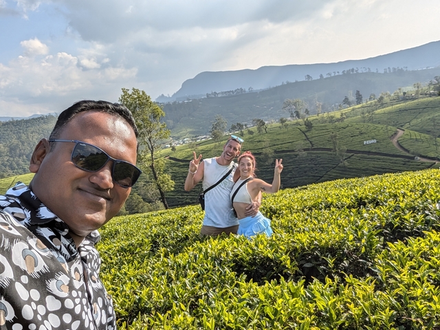 Selfie with a guide and tea plantations in the background.