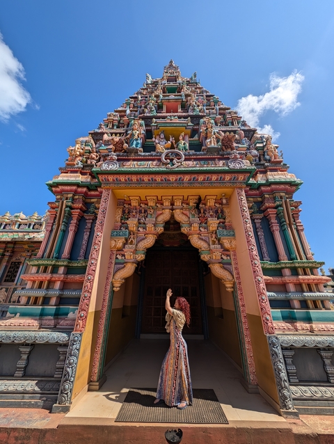 Colorful Hindu temple with intricate carvings in the background.