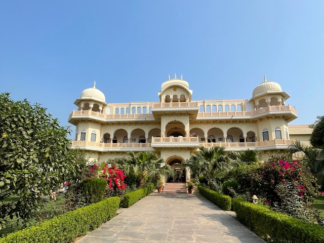 A grand palace with lush gardens and flowers.