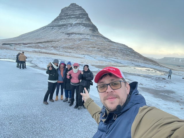 A group of people posing with a mountain backdrop.