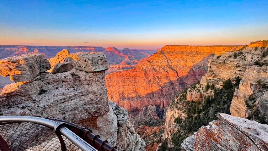 Grand Canyon view with rock formations and sunset lighting.
