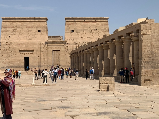       Tourists walking in a temple courtyard.
  