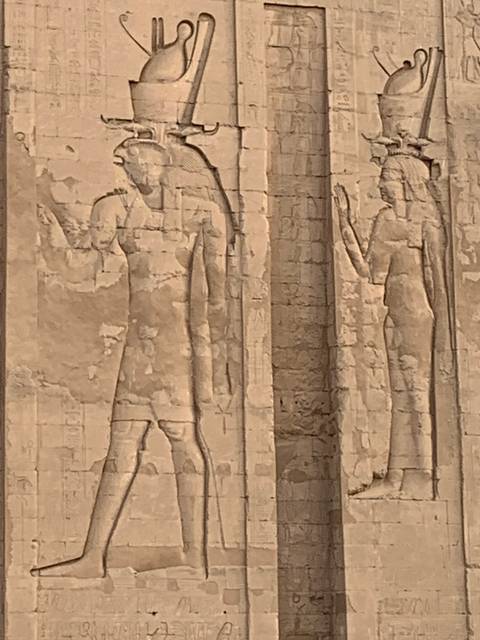       Close-up of faded ancient carvings on a wall.
  