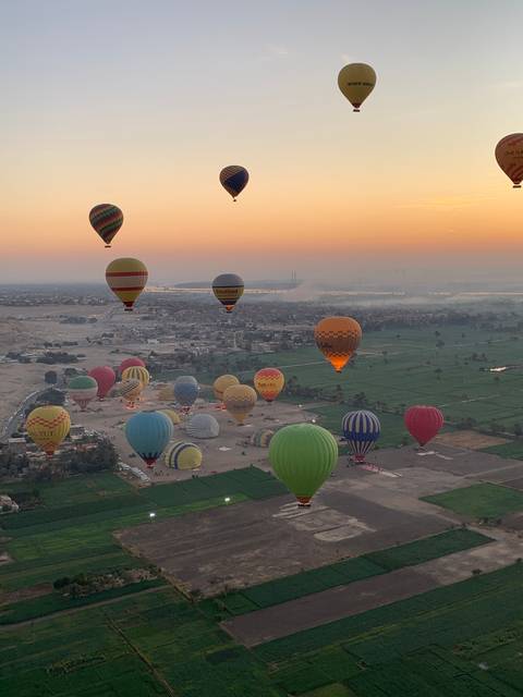       Hot air balloons in the air during sunrise.
  