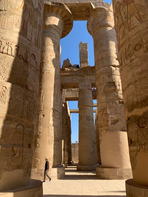       Detailed carvings on thick stone columns in a temple.
  