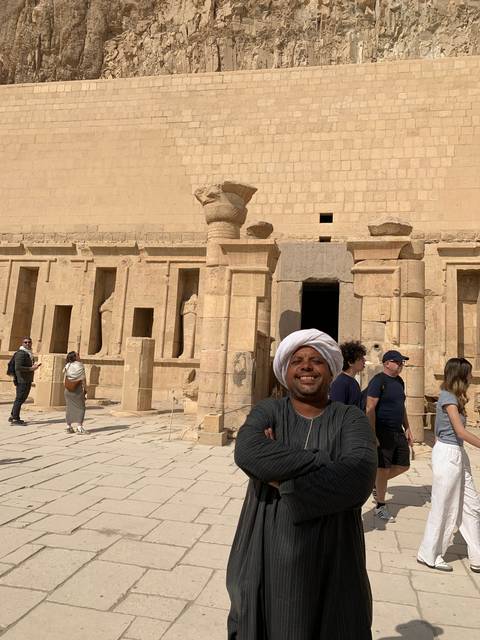       Tourists in front of an ancient temple with columns.
  