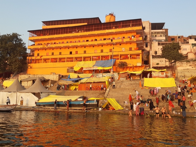       Busy ghats with colorful tents and structures
  