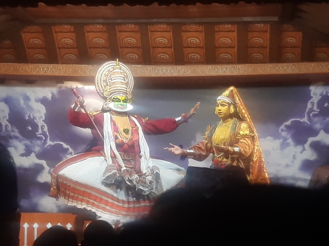       Kathakali performers in traditional attire on a stage
  