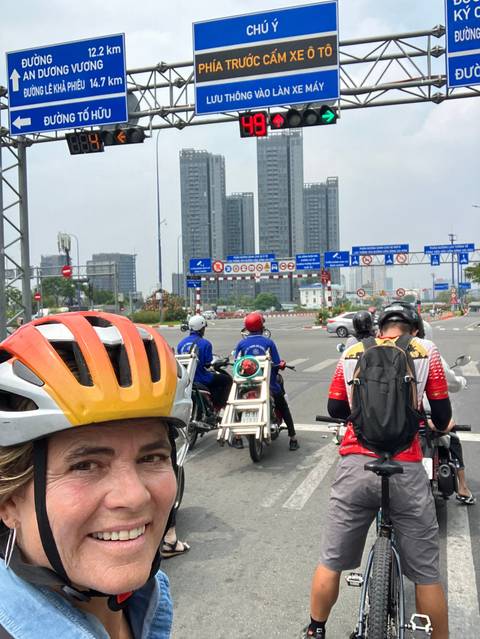 Cyclists waiting at a busy intersection in a city.