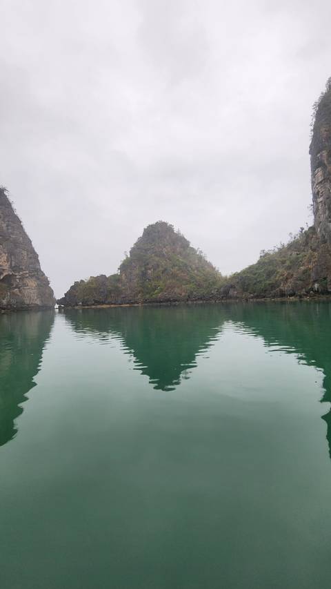 A serene view of rocky islands reflected on the water.