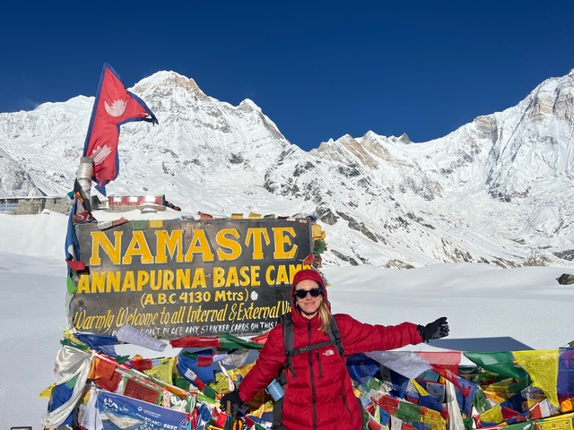 Person at Annapurna Base Camp with mountains in the background.