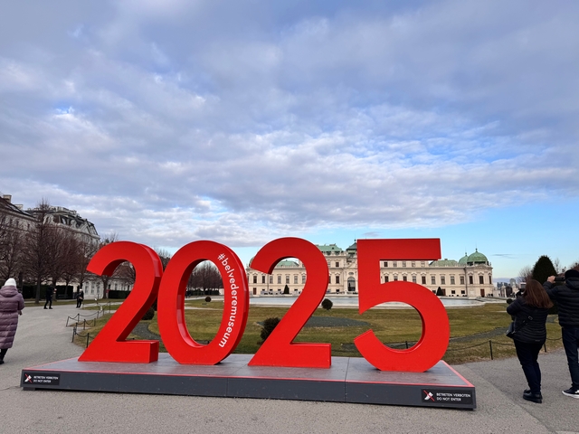 Large red 2025 sign in front of a historic building.